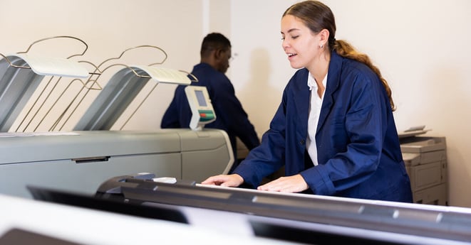 Female worker in a printing and press center check the print quality