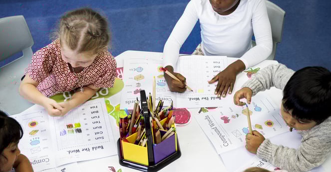 Group of diverse Kids coloring workbook in class