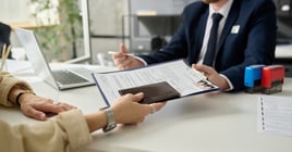 Close up of unrecognizable woman applying for visa in US immigration office and handing documents