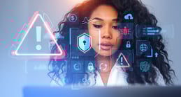 Beautiful young African American woman using laptop with immersive cybersecurity interface. Concept of data protection