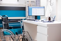 Modern computer on unoccupied desk of wheelchair user physician, displaying upcoming patient medical consultations. Vacant clinical office with desktop pc showing doctors appointment information.