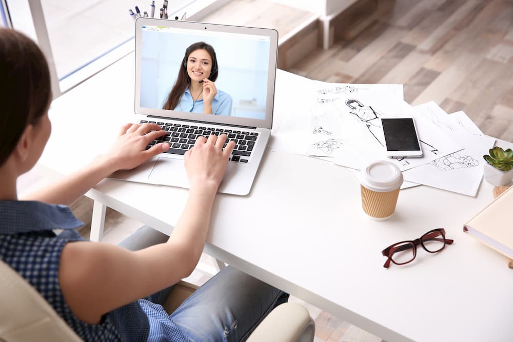 woman communicating with coworker via video conferencing 