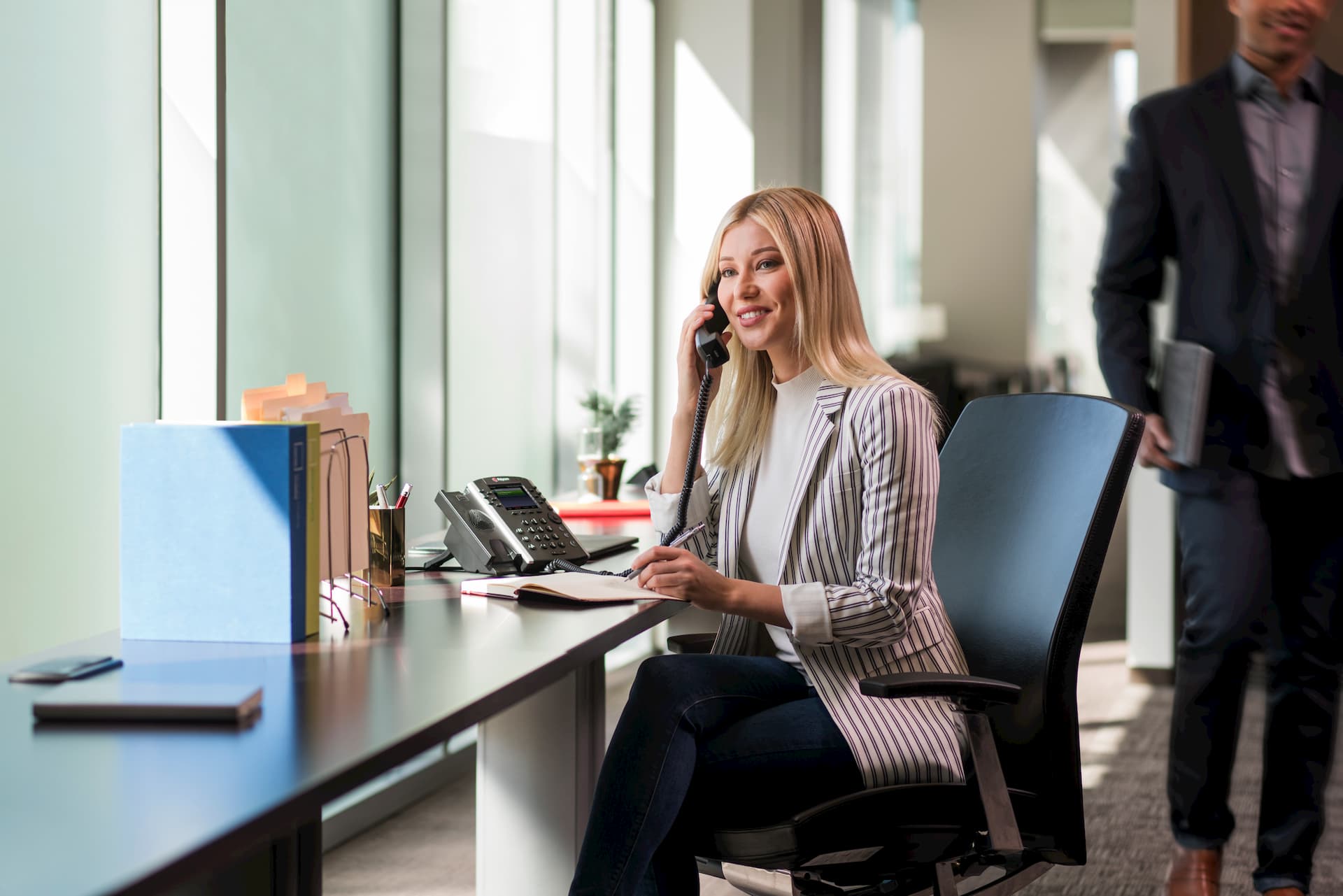 woman using Polycom phone in an open workplace
