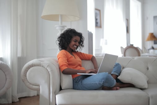 woman-sitting-on-her-couch-working-on-a-remote-work-policy