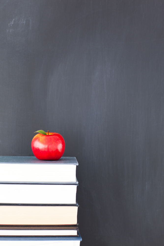 stack-of-books-with-red-apple-and-clean-blackboard.jpg