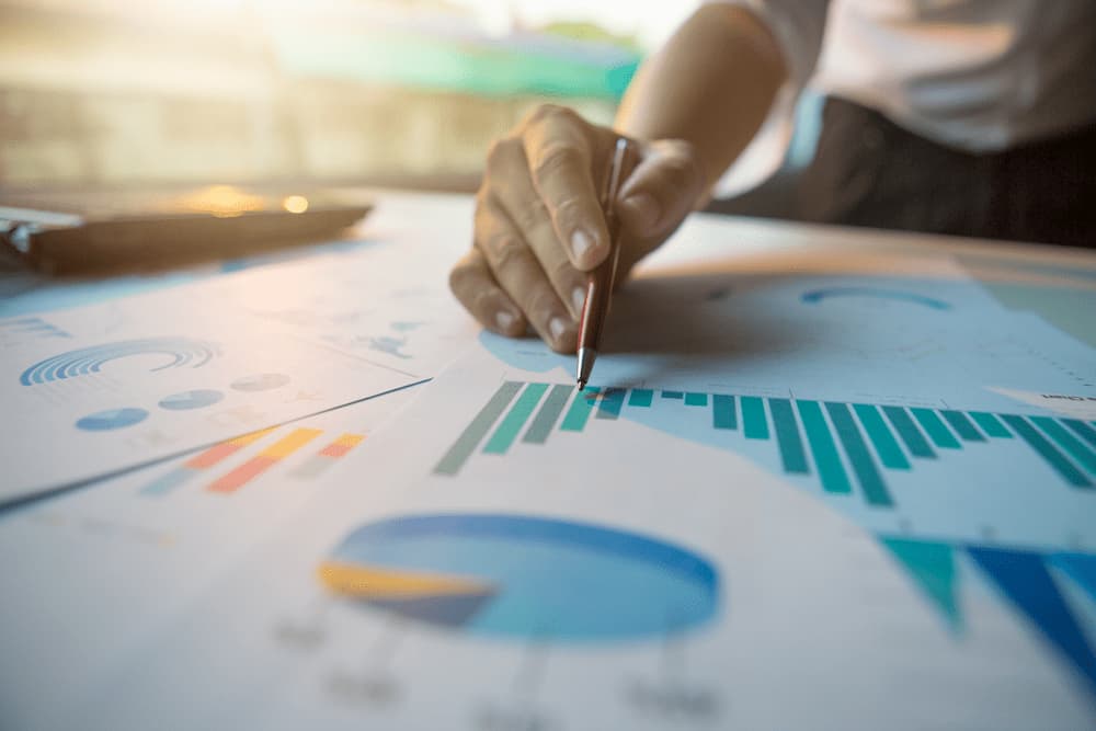 man writing on pie graphs and bar graph sheets