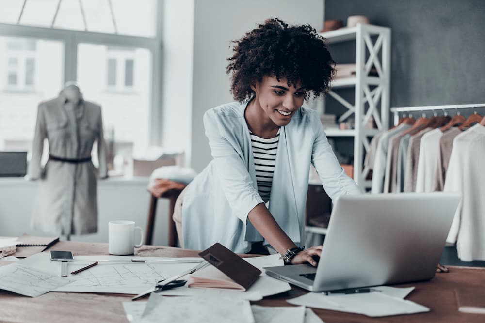 women in clothing store working on computer 