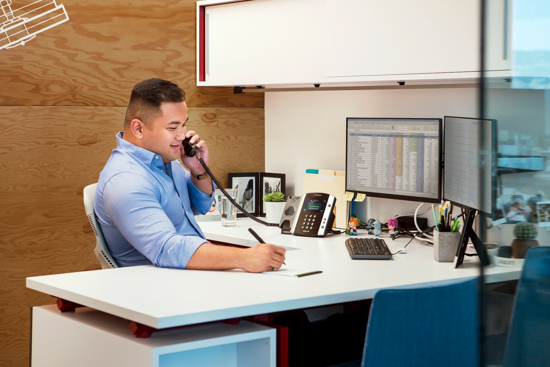 man working on a spreadsheet while communicating using a Hosted PBX phone system