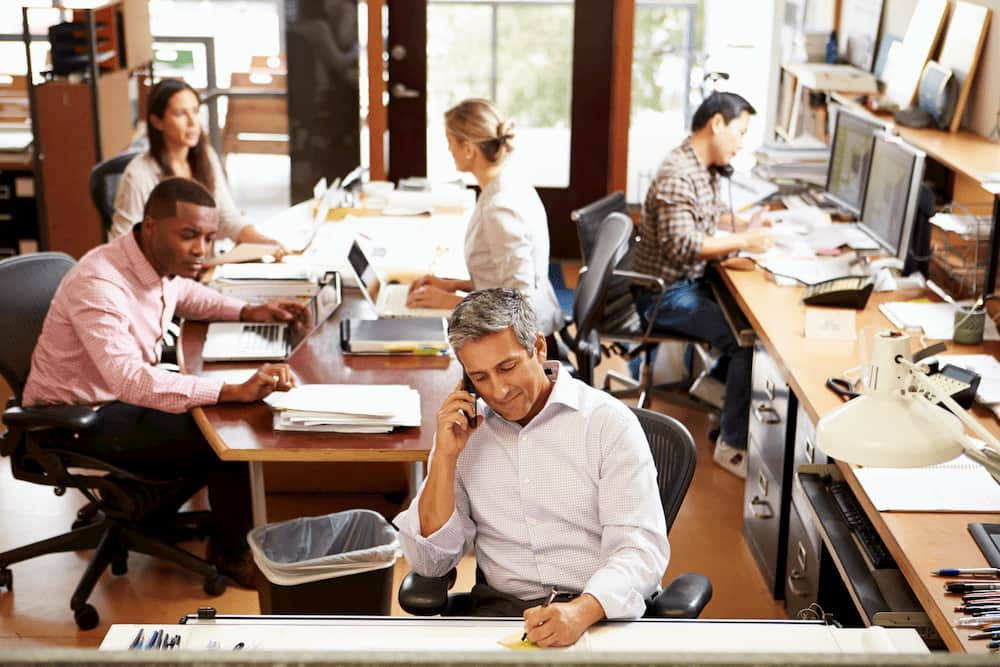 workers-in-office-setting-on-phone